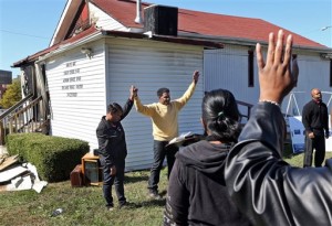 In this Oct. 18, 2015 file photo, Pastor David Triggs and his wife, Charronda, hold hands during an outdoor service following a fire at the church at the New Life Missionary Baptist Church in St. Louis. Authorities announced Friday, Oct. 30, 2015 the arrest of a 35-year-old black man suspected of setting fires at several predominantly African-American St. Louis-area churches that spurred a hate-crime investigation. (J.B. Forbes/St. Louis Post-Dispatch via AP, File) EDWARDSVILLE INTELLIGENCER OUT; THE ALTON TELEGRAPH OUT; MANDATORY CREDIT