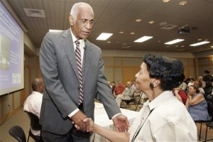 In this Aug. 1, 2007 file photo, Milton Crenchaw, who was a member of the first all-black unit in the Army Air Corps during World War II known as the Tuskegee Airmen, left, speaks with Thessia Dunn before participating in a lecture series at the Butler Center for Arkansas Studies in Little Rock, Ark. Chrenchaw died Tuesday, Nov. 17, 2015, in Georgia. He was 96. (AP Photo/Danny Johnston, File)