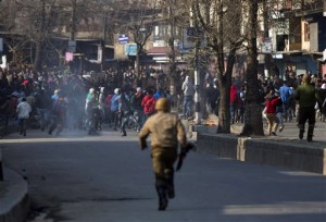 An Indian policeman chases Kashmiri Muslim protesters during a protest in Srinagar, Indian controlled Kashmir, Friday, Feb. 19, 2016. Government forces fired tear gas and pellet guns to stop hundreds of rock-throwing Kashmiri youths in Indian-controlled Kashmir after Friday prayers. They were protesting the arrest of a Delhi University lecturer, S.A.R. Geelani, and a student leader of the Jawaharlal Nehru University (JNU) on charges of sedition for raising anti-India slogans. Geelani also allegedly criticized the 2013 hanging of a Kashmiri man Afzal Guru convicted of attacking Indian Parliament. (AP Photo/Dar Yasin)