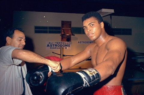 Muhammad Ali gets his gloves laced outside a boxing ring in Houston, Texas in February 1967. Ali is training for a Feb. 6 championship title fight with Ernie Terrell. (AP Photo)