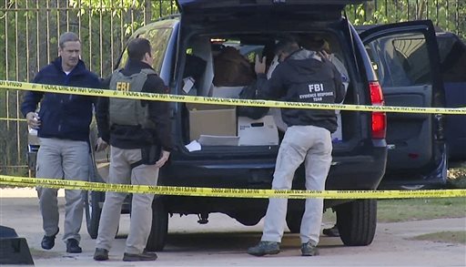 In this April 10, 2014, file photo taken from video, FBI agents collect evidence at an apartment complex in Atlanta, where federal agents rescued kidnap victim Frank Janssen, of Wake Forest, N.C. Kelvin Melton, a violent criminal described as a high-ranking member of the Bloods street gang goes on trial Monday, June 6, 2016, in North Carolina on a federal kidnapping charge after authorities say he helped orchestrate the abduction of Janssen, a prosecutor's father, from his prison cell. (AP Photo/Johnny Clark, File)